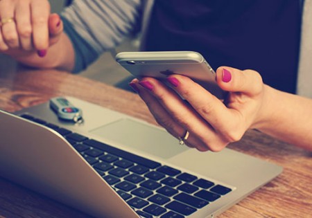 Woman working and looking at cell phone.
