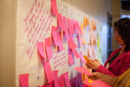 Participants reading quotes and ideas on GenEQ wall at launch event