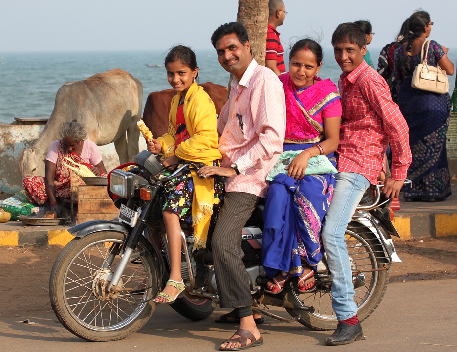 A family packs onto a motorcycle in India for a photo