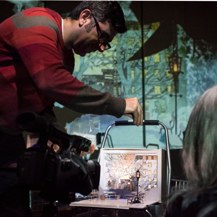 Troy shooting with video camera with mini set while person watches