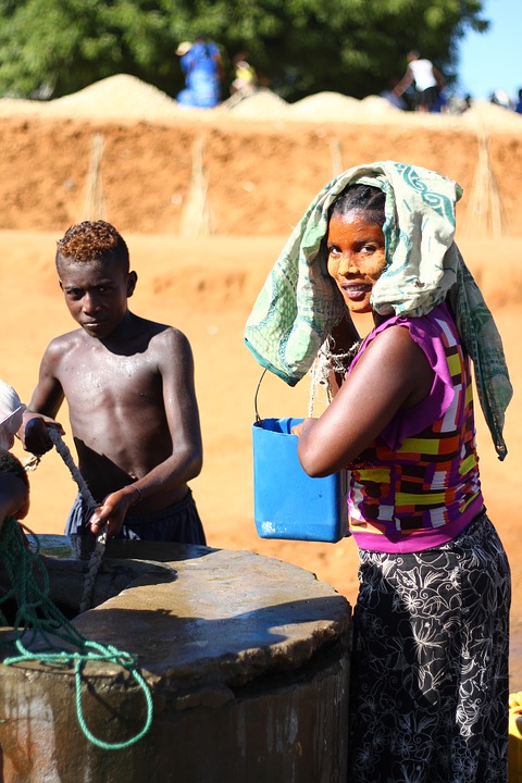 boy and woman collecting water from a well in Madagascar
