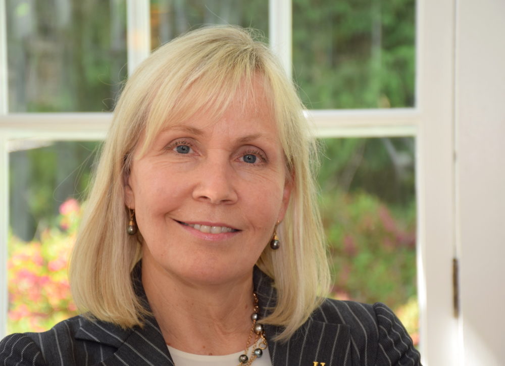 Portrait of a blond woman in front of a window
