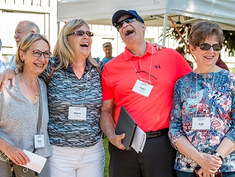 Four grads laugh together in this photo.