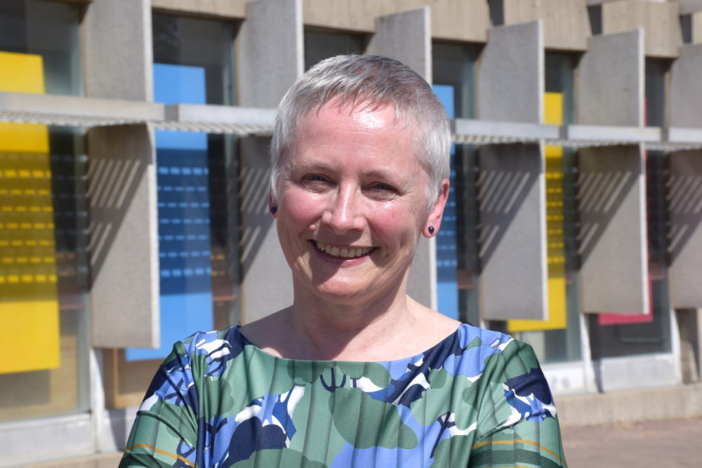 Professor outdoors on campus, short hair