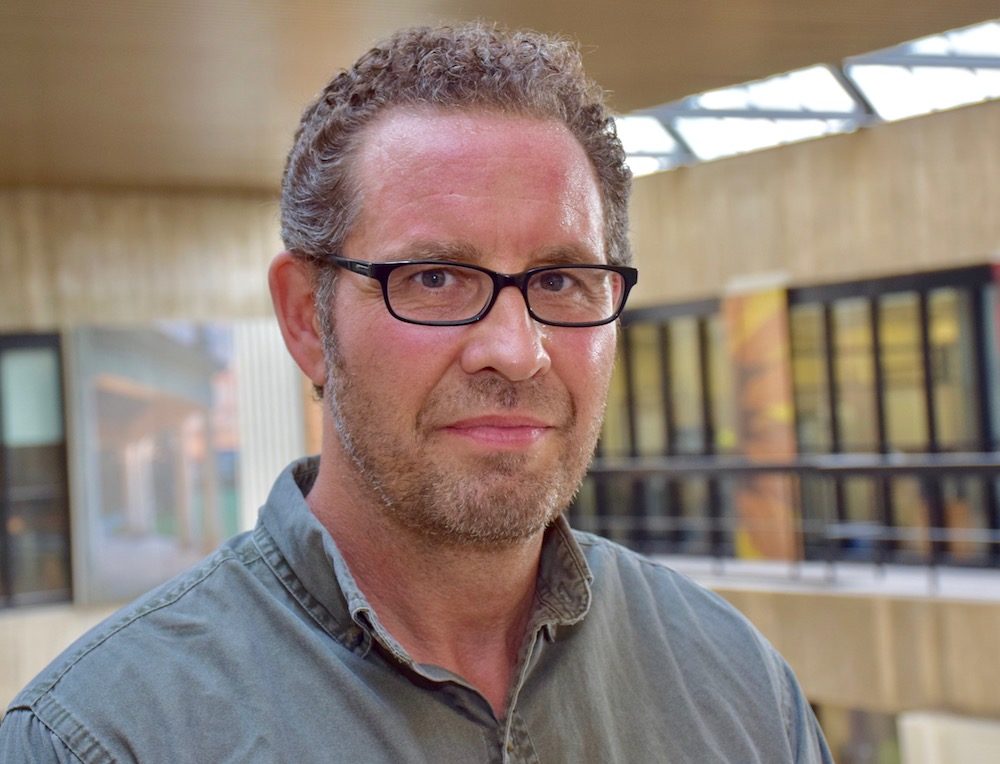 Man with glasses in indoor U of G setting