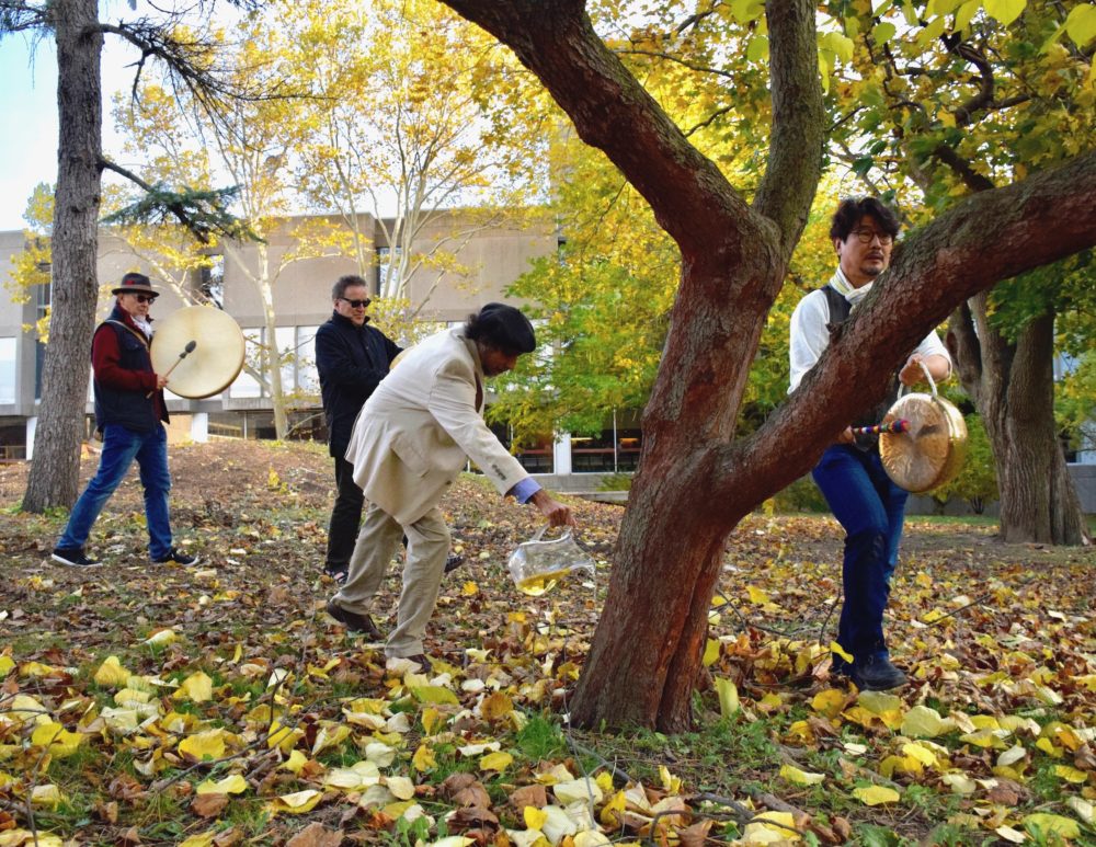 Men perform a ritual on the grounds of U of G