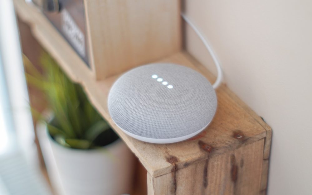A Google Home speaker sits on a shelf