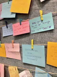Notes of encouragement are pinned to a library wall