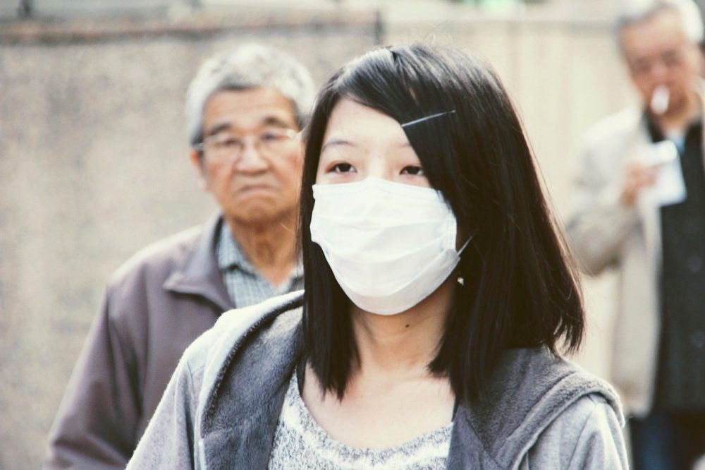 A woman wears a surgical mask