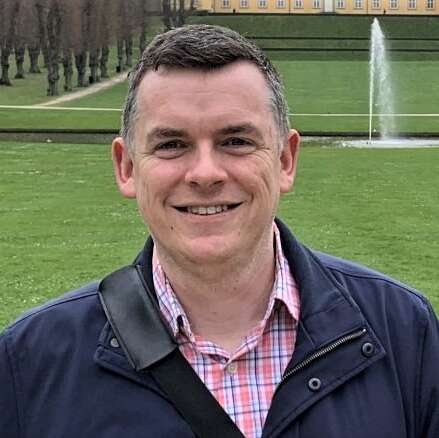 Dr. Matthew Hayday in front of a fountain.