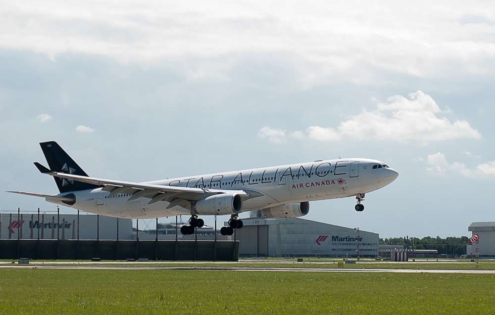 An Air Canada flight begins takeoff at an airport