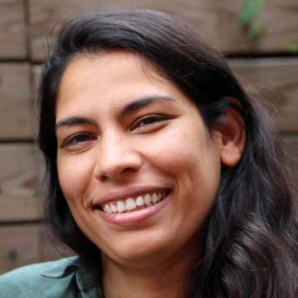 Dr. Jackie Goordial in front of a brick wall