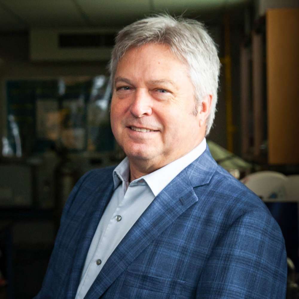 Dr. Mike Dixon in plaid suit jacket and blue button up shirt.