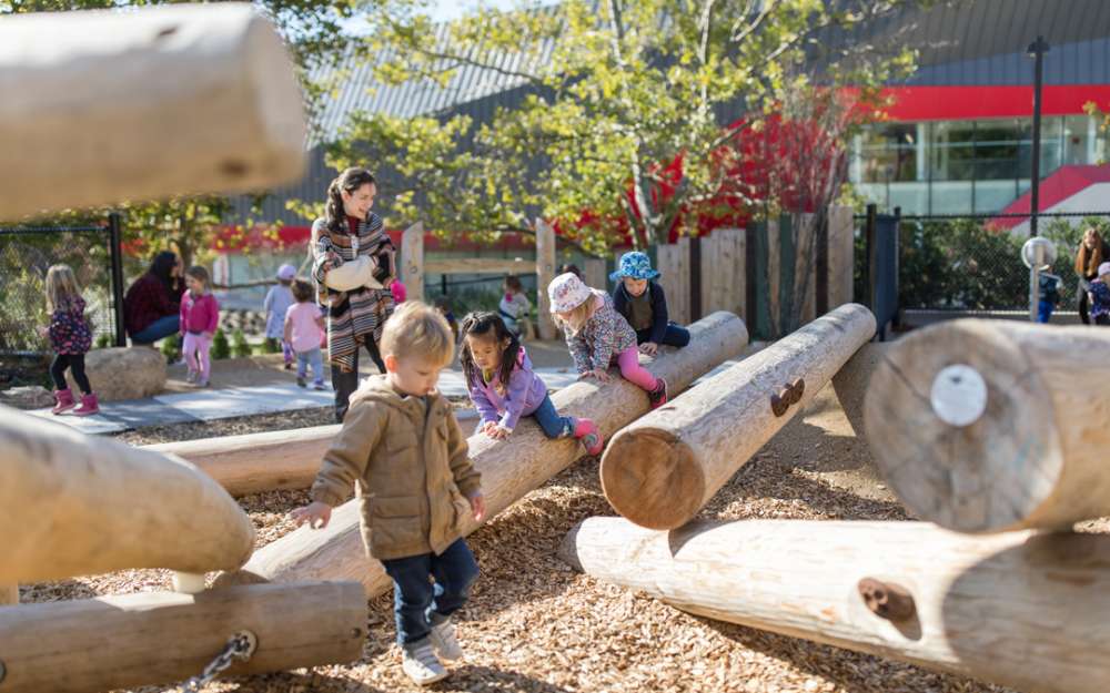 Children play on sloped log climbers