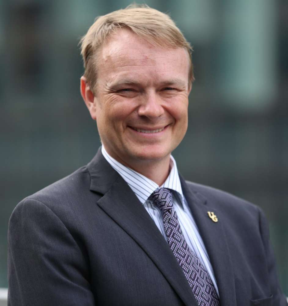 Dr. Evan Fraser wears a suit and poses for a portrait