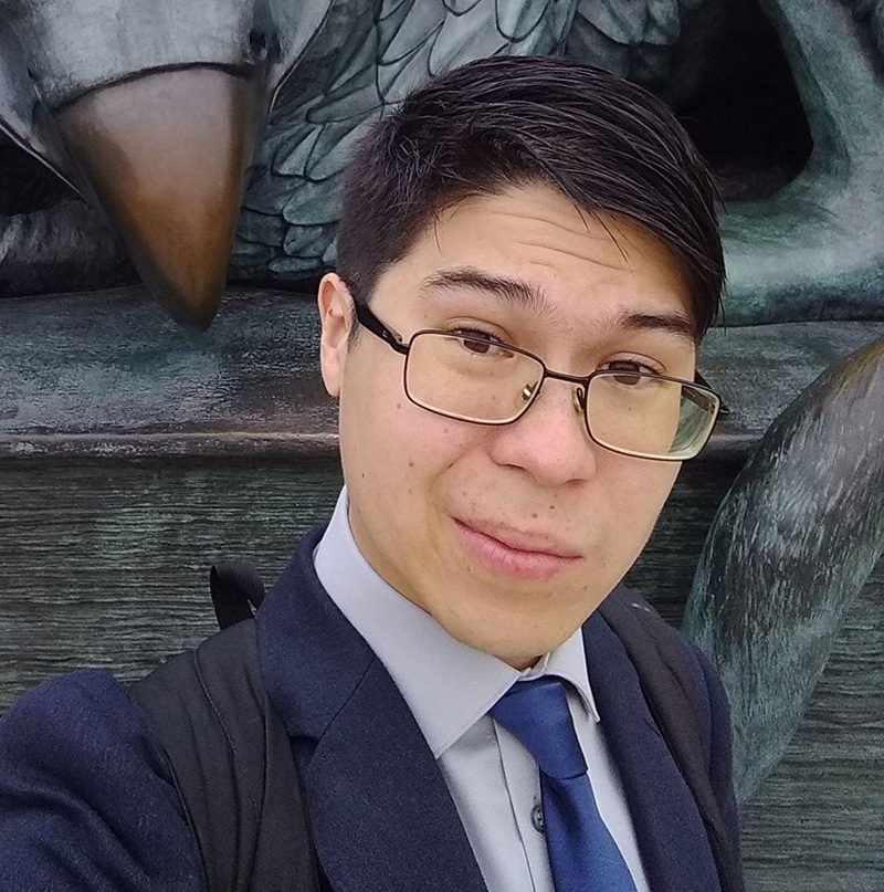 Dr. Andrew D. Young takes a selfie in front of the Gryphon statue on U of G's campus.