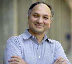 Dr. Manish Raizada in front of grey pillars.