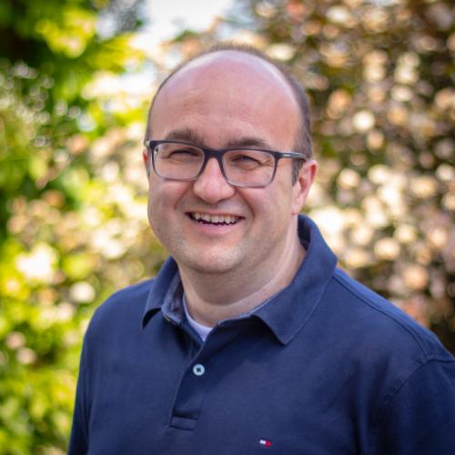 Dr. Dennis Baker poses for a headshot outdoors.