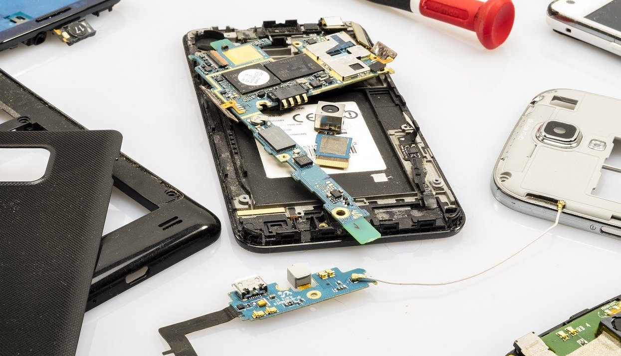 A dismantled cellphone is shown on a desk