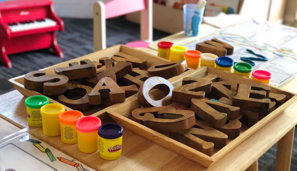 A low table with play-doh containers and block letters