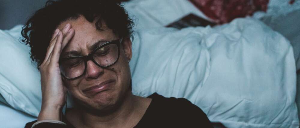 person crying beside bed