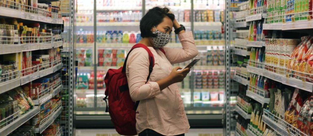 woman in red long sleeve shirt and black pants standing on white floor tiles