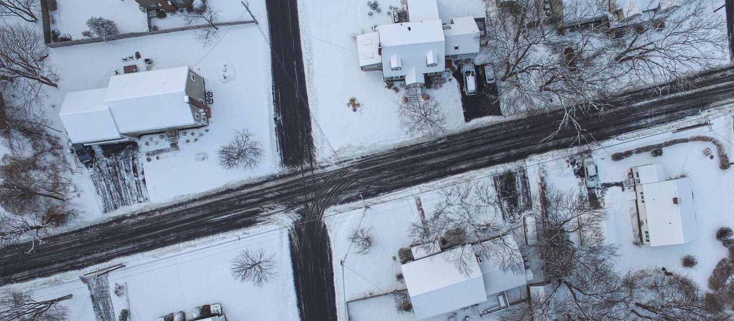 Top view of residential street blanketed in snow.