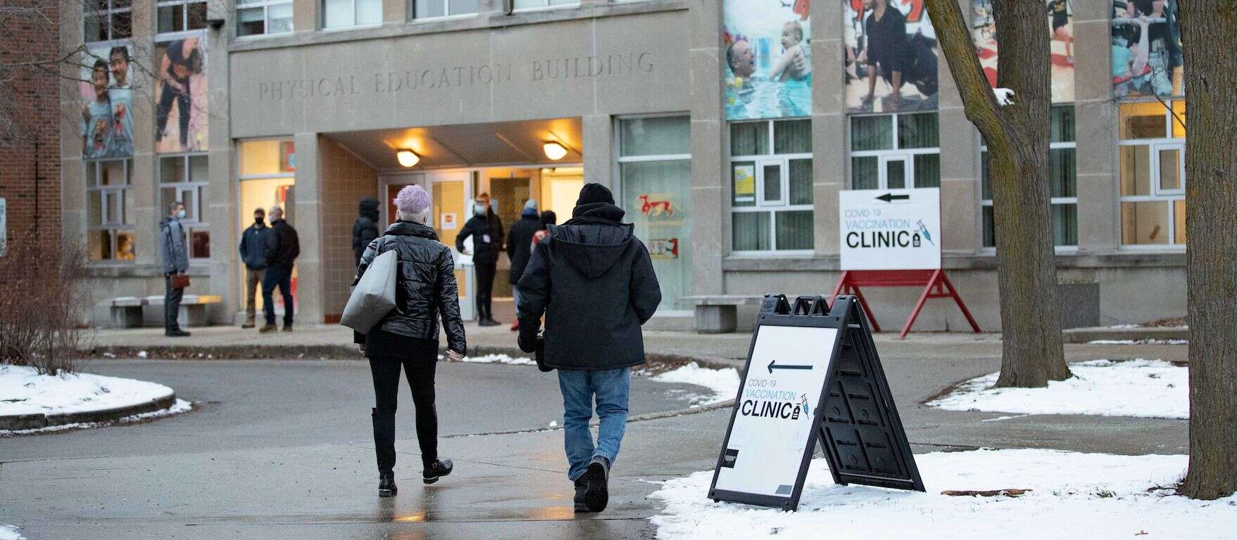 Several people shown from behind as they walk into the Physical Education Building on the U of G campus