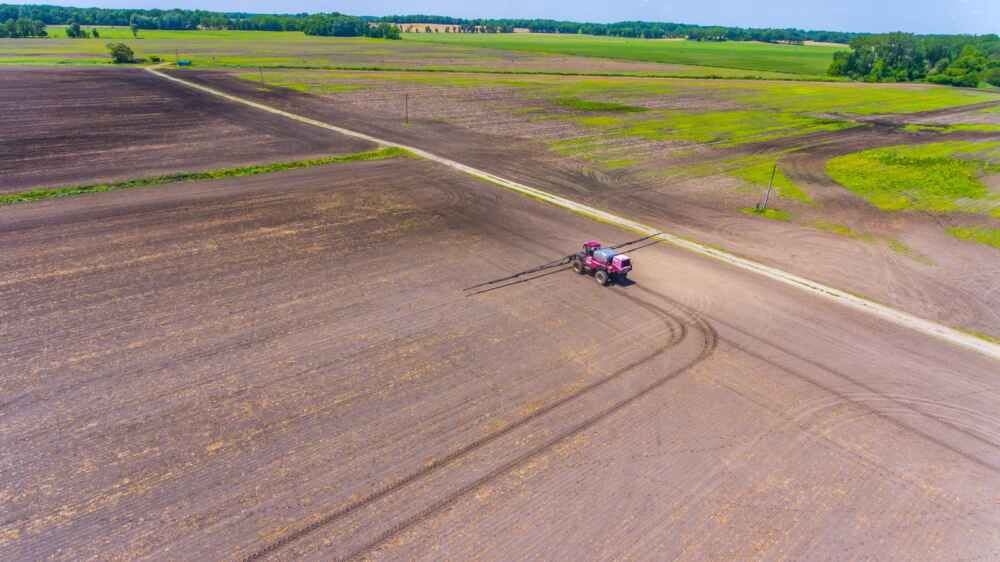 A sprayer applies fertilizer to a field.