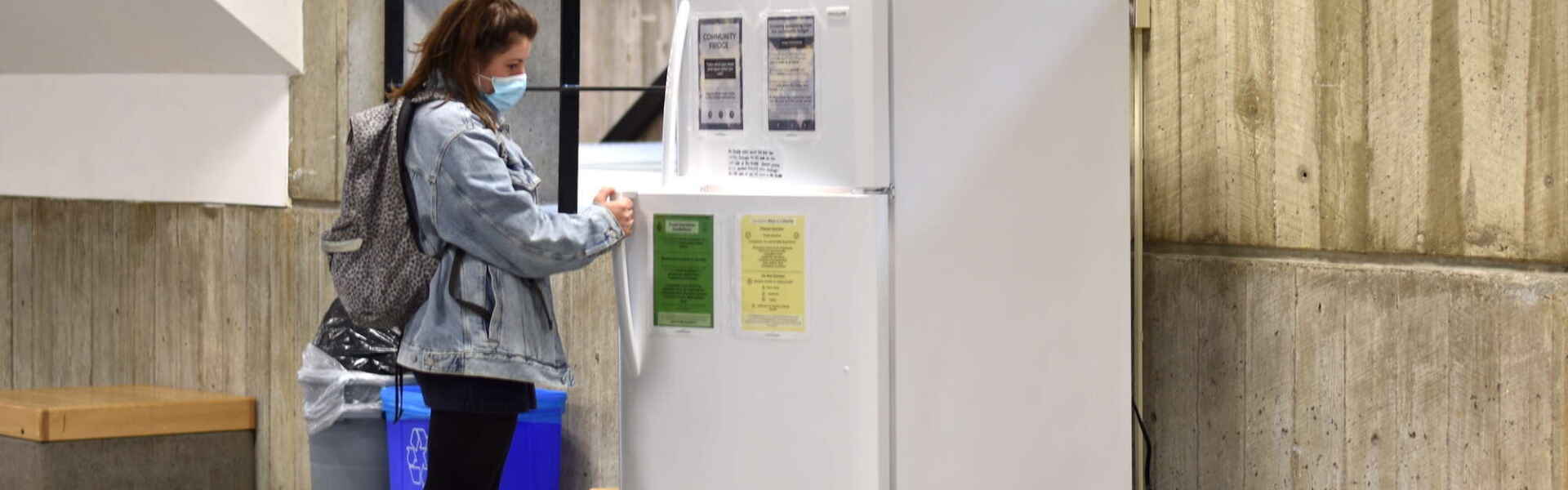 A student is shown opening the door of the community fridge