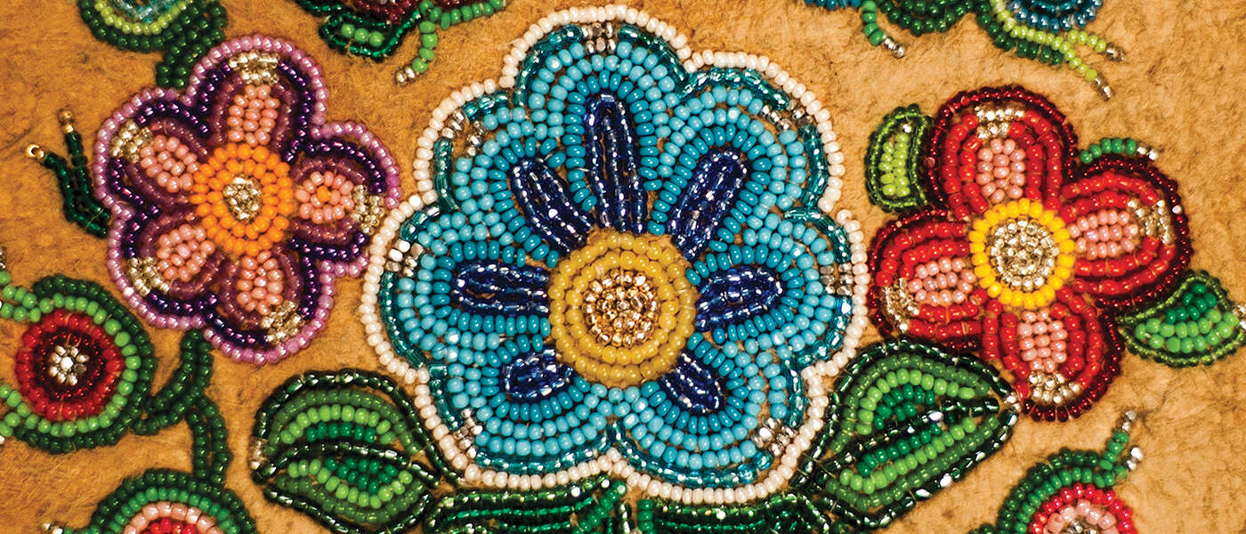A closeup of moccasin beadwork showing flowers and vines