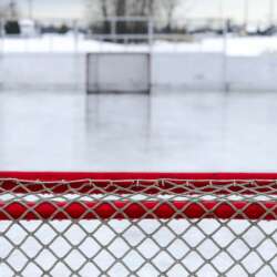 A red and white goal net on ice field