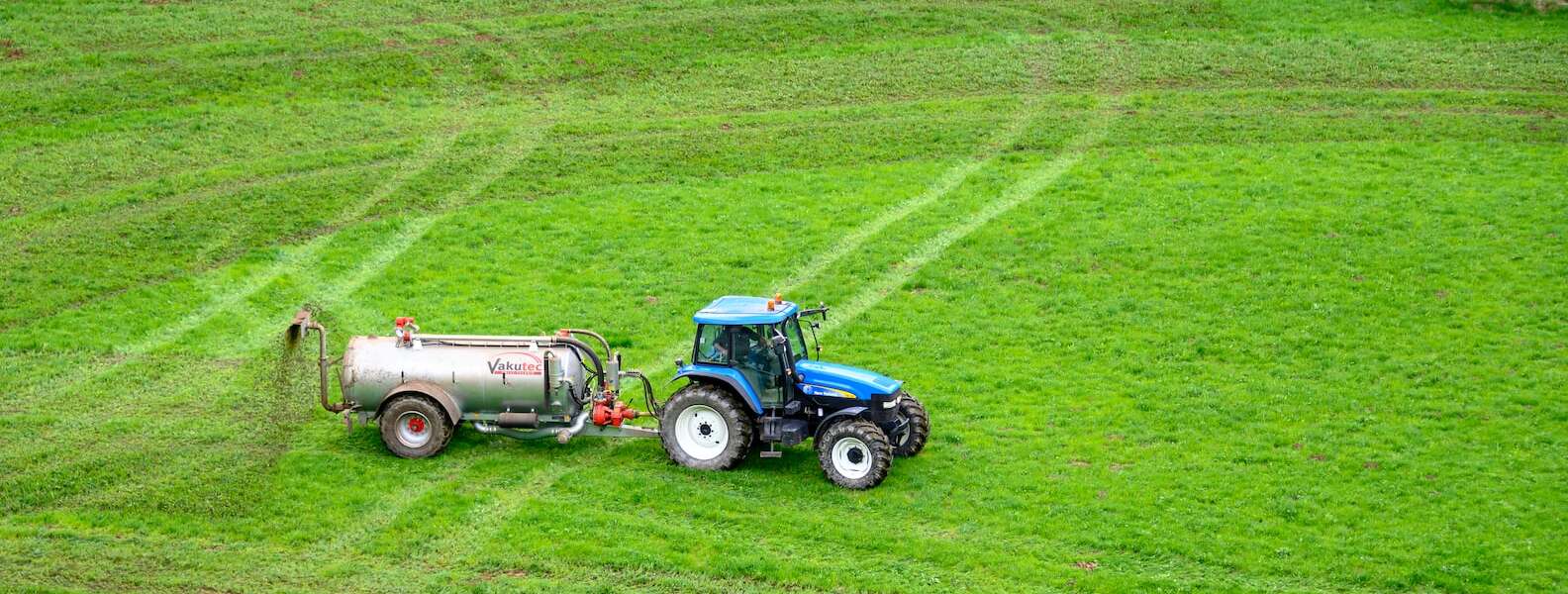 wide shot of a tractor on grass field
