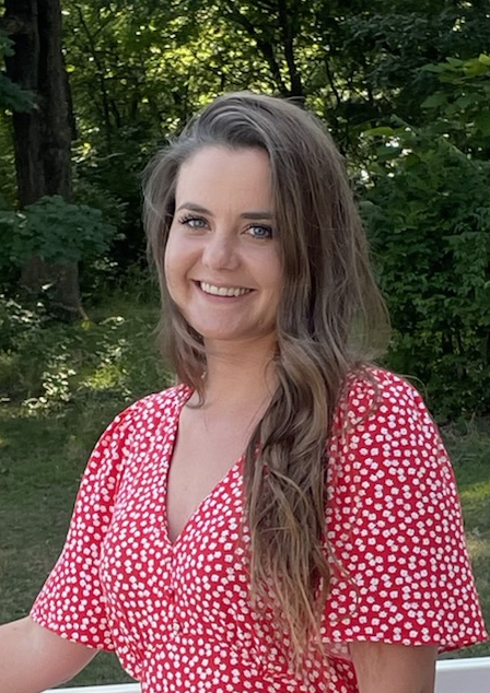 Marie Gutgesell poses in front of a wooded area