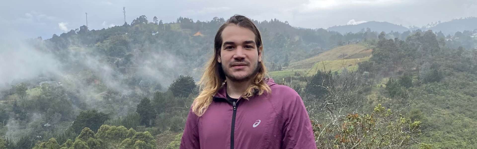 Sebastian Hamid stands ata foggy valley lookout in Colombia