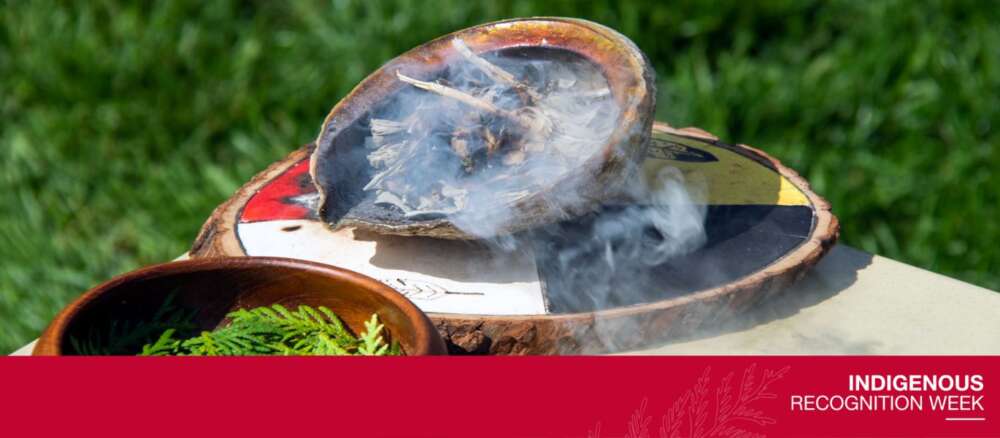Smoke from Indigenous medicines in an abalone shell atop a painting of a Medicine Wheel. Text reads: Indigenous Recognition Week