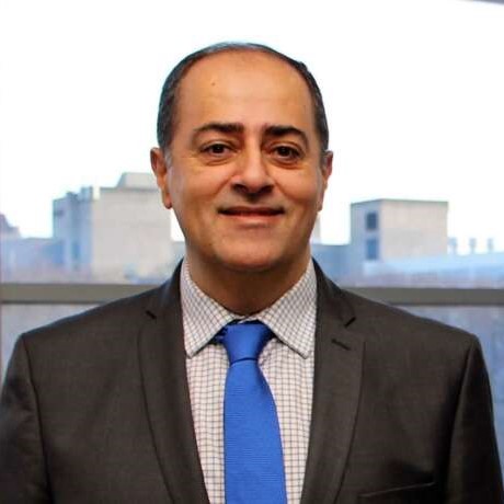 Dr. Shayan Sharif poses for a photo in front of a window