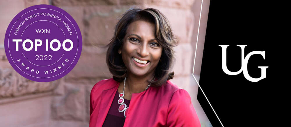 Indira Naidoo-Harris smiles near a sandstone building. The Top 100 logo is to the left; the U of G logo is to the right