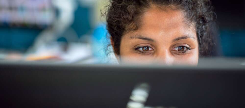 A woman watches their computer screen
