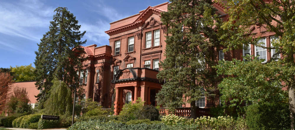 A red brick building with a green lawn in front of it,