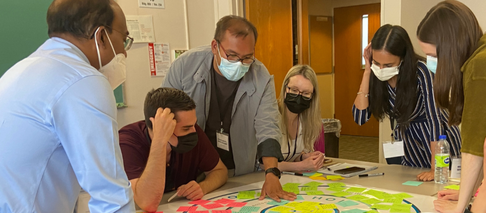 students and instructors working on a net-zero activity at a table