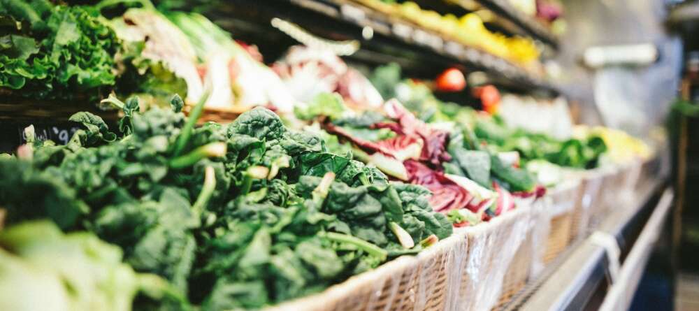 row of vegetables placed on multilayered display fridge