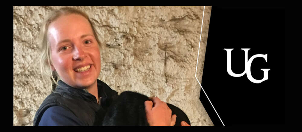 A smiling Allison Visser against a stone wall