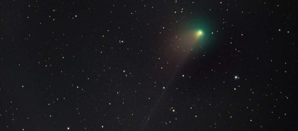 A green comet in a starry sky