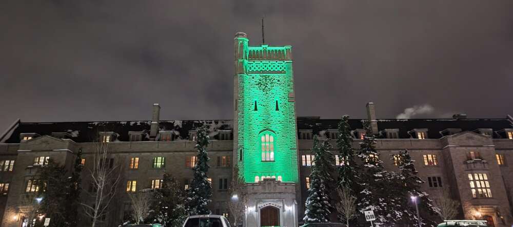 Johnston Hall at night in winter lit in green