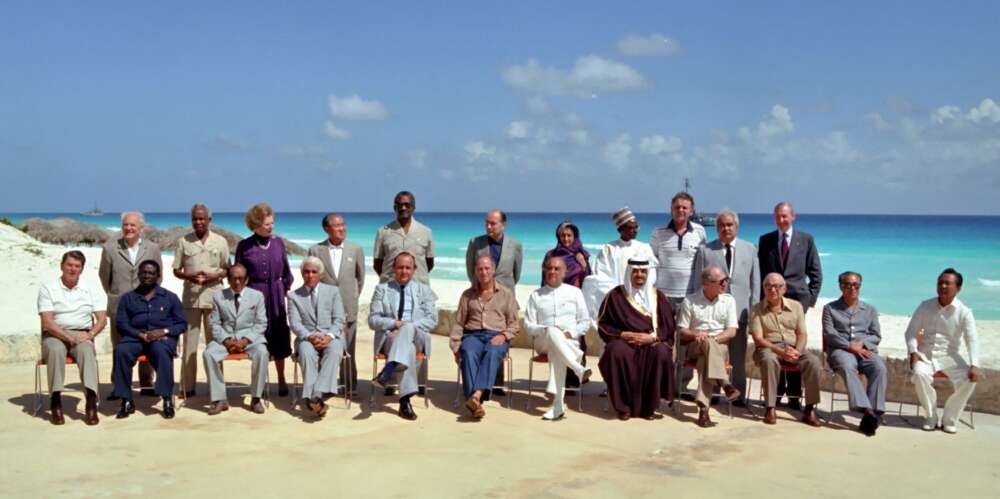 Twenty-one Heads of state and government pose for a photo on a beach in Cancun