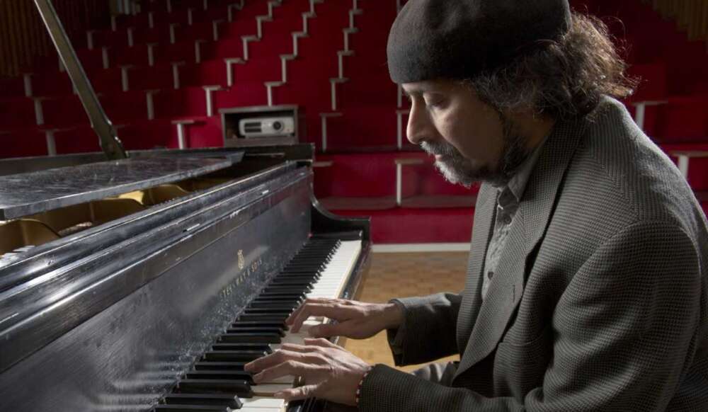 Dr. Ajay Heble plays a grand piano in a theatre