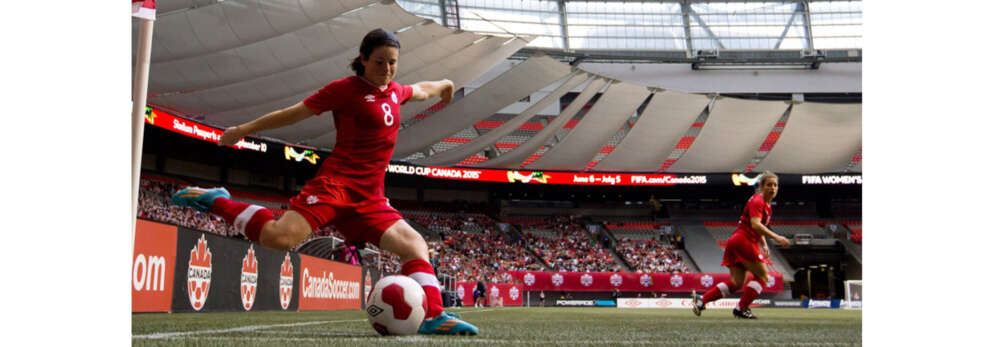 A photos oDiana Matheson setting up to kick the ball in a large soccer arena