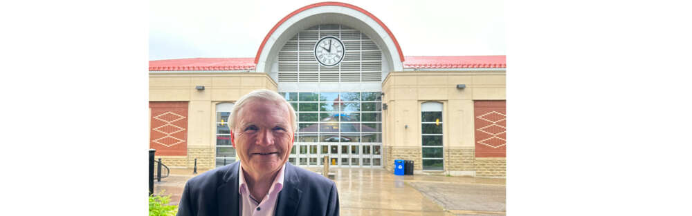 a man poses for a photo outside of Rozanski Hall on the U of G campus