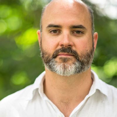 Close-up of Dr. Pat Barclay posing against a leafy background